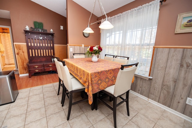 dining area with tile patterned flooring and wood walls