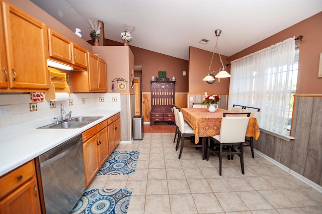 kitchen with stainless steel dishwasher, sink, decorative light fixtures, lofted ceiling, and light tile patterned flooring