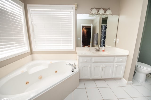 bathroom with tile patterned flooring, vanity, toilet, and tiled bath