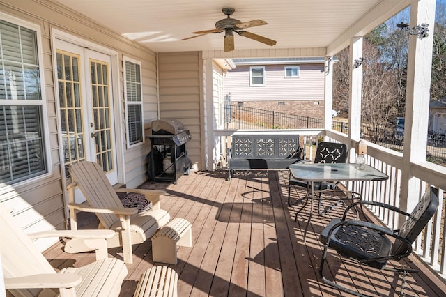 wooden terrace featuring a grill, ceiling fan, and french doors