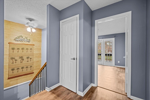 corridor featuring wood-type flooring and a textured ceiling