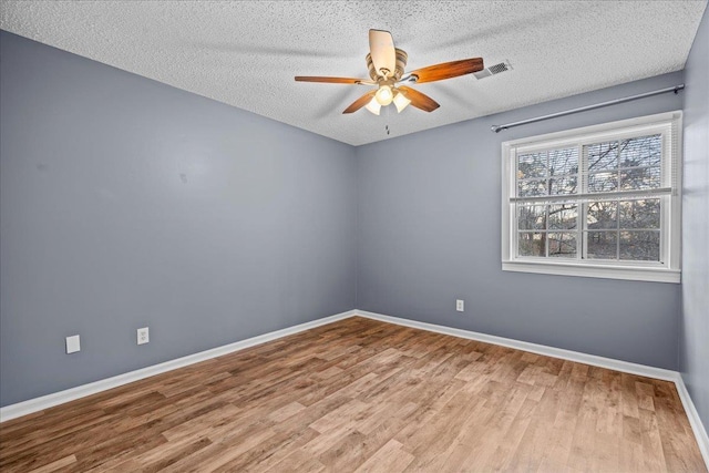 spare room with hardwood / wood-style floors, ceiling fan, and a textured ceiling