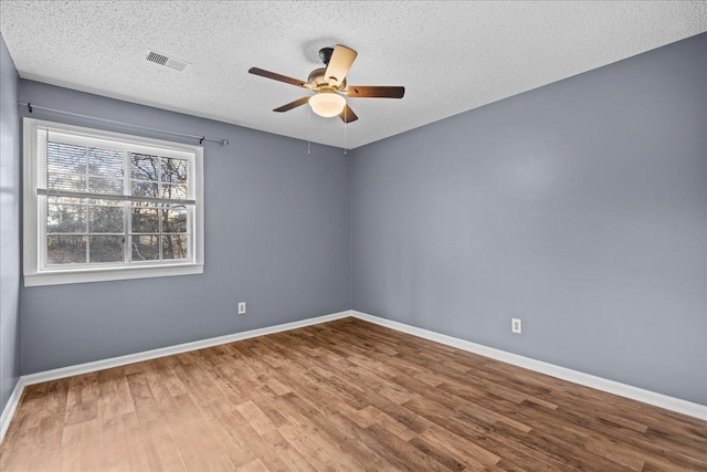 spare room with hardwood / wood-style floors, ceiling fan, and a textured ceiling