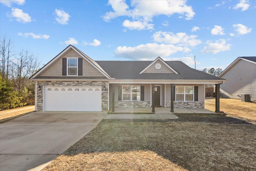 view of front of home with cooling unit, covered porch, and a front yard