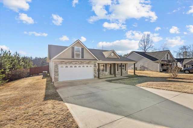 view of front of house featuring cooling unit, a front lawn, covered porch, and a garage