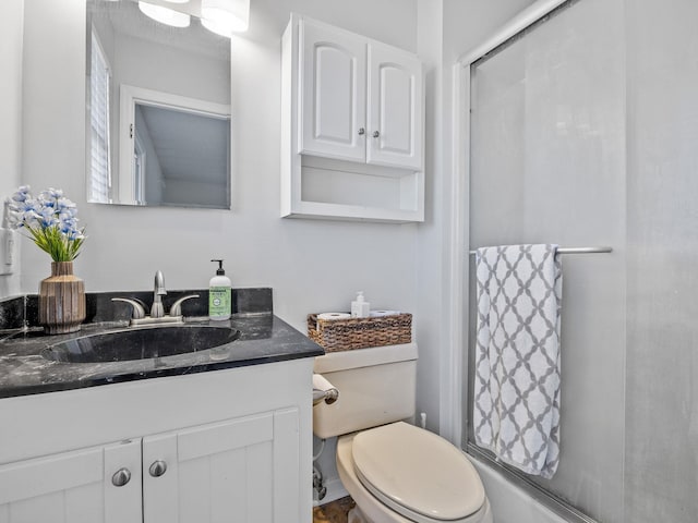 bathroom featuring vanity, toilet, and walk in shower