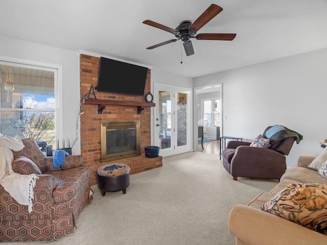 carpeted living room featuring ceiling fan and a brick fireplace