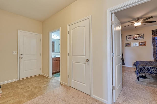 corridor featuring sink and light carpet