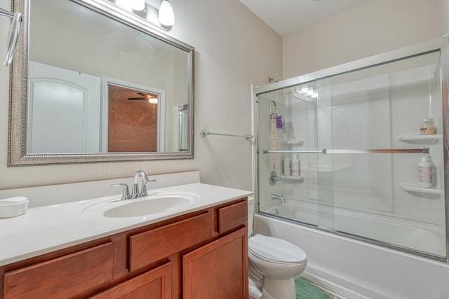 full bathroom featuring shower / bath combination with glass door, vanity, and toilet