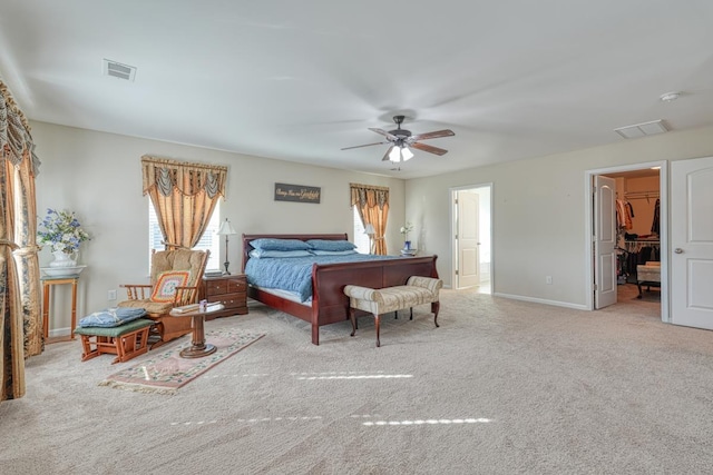 bedroom with light carpet, a closet, a spacious closet, and ceiling fan