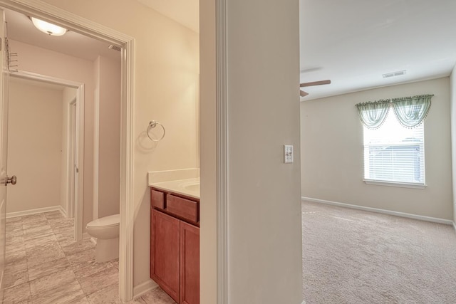 bathroom featuring ceiling fan, vanity, and toilet