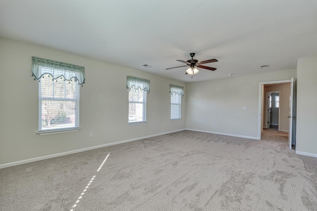 carpeted empty room with plenty of natural light and ceiling fan