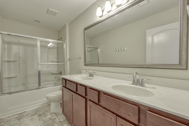 full bathroom with vanity, toilet, and bath / shower combo with glass door