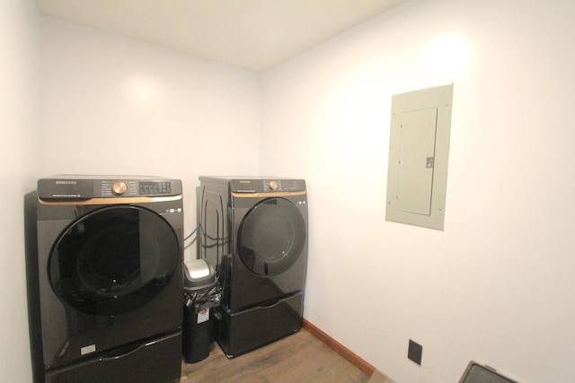 laundry area with wood-type flooring, independent washer and dryer, and electric panel