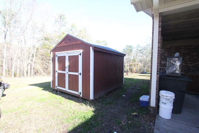 view of outbuilding featuring a playground and a yard