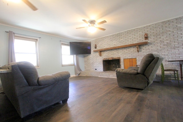 living room with a brick fireplace, dark hardwood / wood-style floors, ceiling fan, ornamental molding, and brick wall