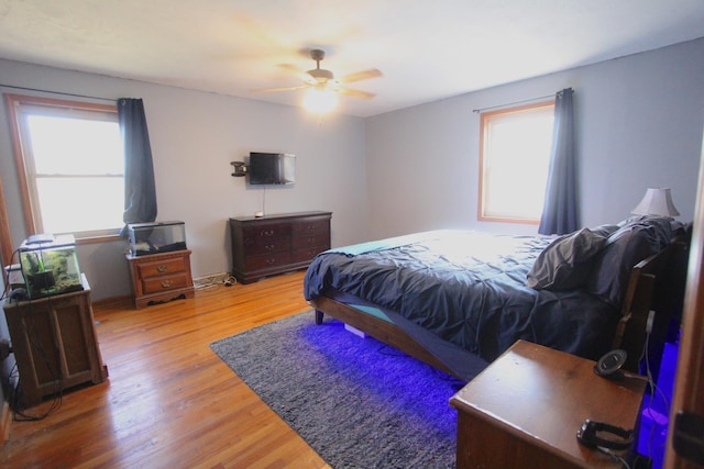 bedroom with multiple windows, ceiling fan, and hardwood / wood-style floors