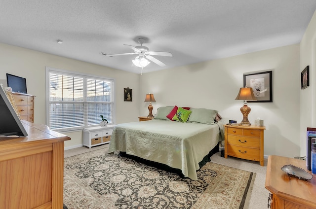 bedroom with ceiling fan and a textured ceiling