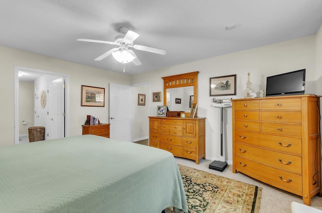 bedroom with ensuite bathroom, ceiling fan, and light colored carpet