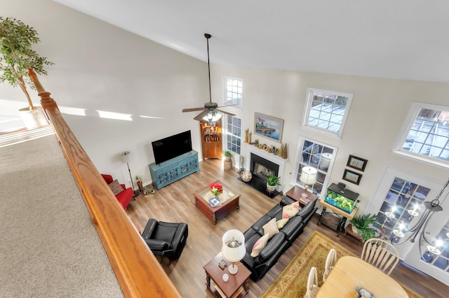 living room with a high ceiling, hardwood / wood-style flooring, and ceiling fan