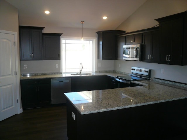 kitchen featuring light stone counters, stainless steel appliances, sink, pendant lighting, and lofted ceiling