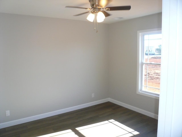 empty room with ceiling fan, plenty of natural light, and dark hardwood / wood-style floors