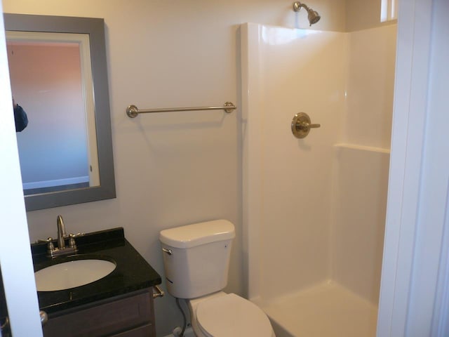 bathroom featuring vanity, toilet, and walk in shower