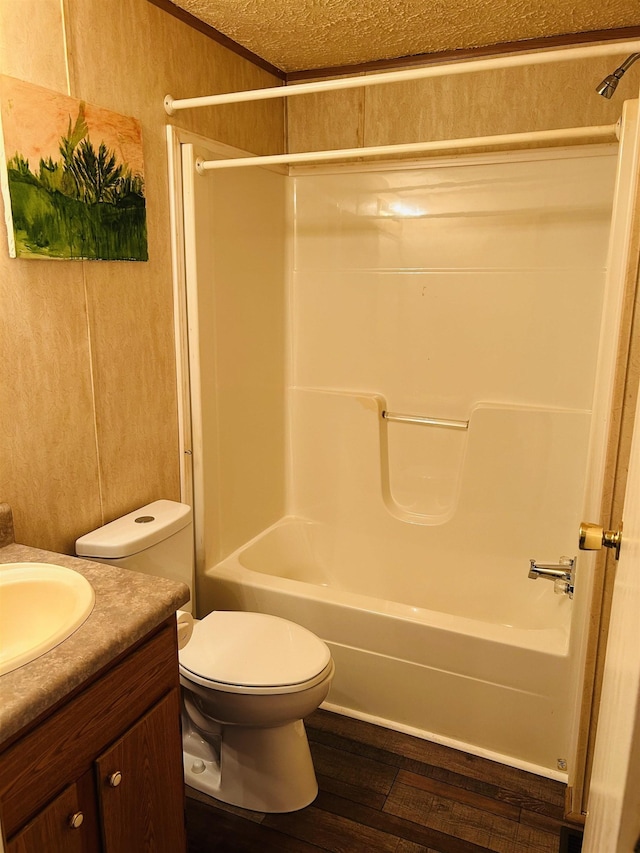 full bathroom featuring hardwood / wood-style floors, vanity, toilet, and washtub / shower combination