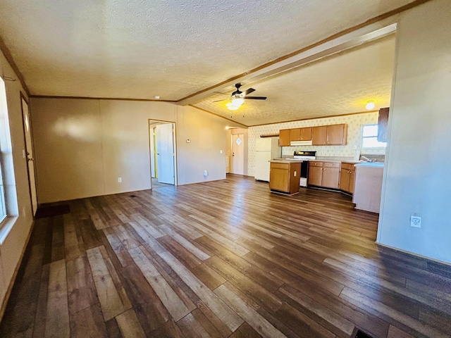 unfurnished living room with vaulted ceiling with beams, ceiling fan, dark hardwood / wood-style flooring, and a textured ceiling