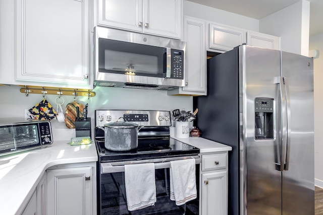 kitchen with white cabinetry, stainless steel appliances, and dark wood-type flooring