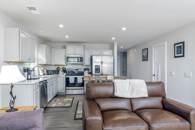 kitchen with dark hardwood / wood-style flooring, white cabinetry, sink, and appliances with stainless steel finishes