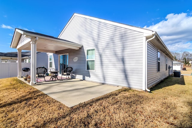 rear view of property with a yard, central AC, and a patio area