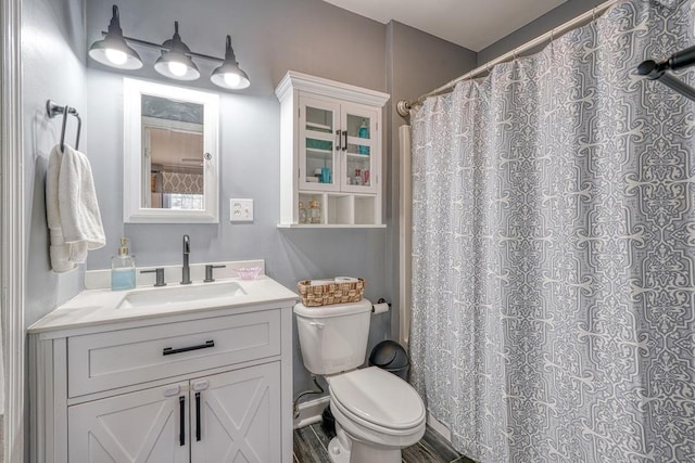 bathroom featuring a shower with curtain, vanity, and toilet