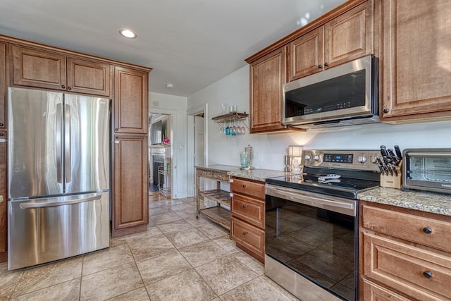 kitchen with light stone countertops and appliances with stainless steel finishes