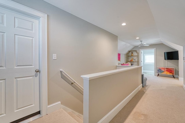 corridor with light carpet and lofted ceiling