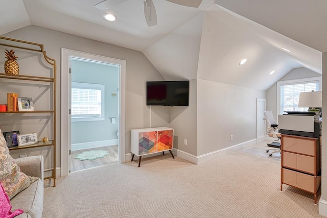 office featuring ceiling fan, light colored carpet, and lofted ceiling