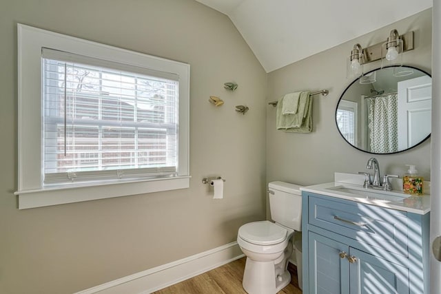 bathroom with hardwood / wood-style floors, vanity, lofted ceiling, and toilet