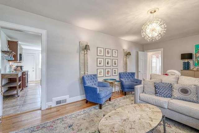 living room with light wood-type flooring and a chandelier