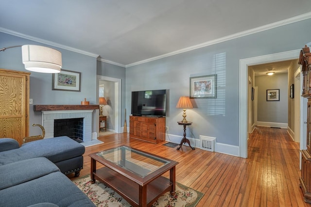 living room featuring hardwood / wood-style floors, a brick fireplace, and ornamental molding