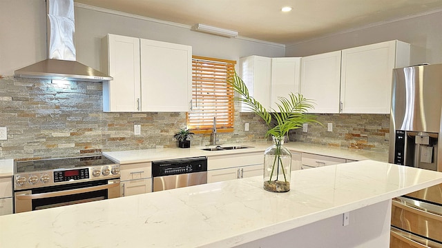 kitchen featuring sink, wall chimney exhaust hood, stainless steel appliances, light stone counters, and white cabinets