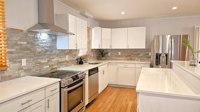 kitchen featuring white cabinetry, wall chimney range hood, stainless steel appliances, and tasteful backsplash