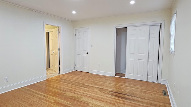 unfurnished bedroom featuring wood-type flooring and ornamental molding