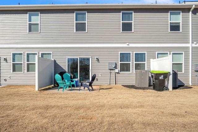 back of property featuring a lawn and central air condition unit