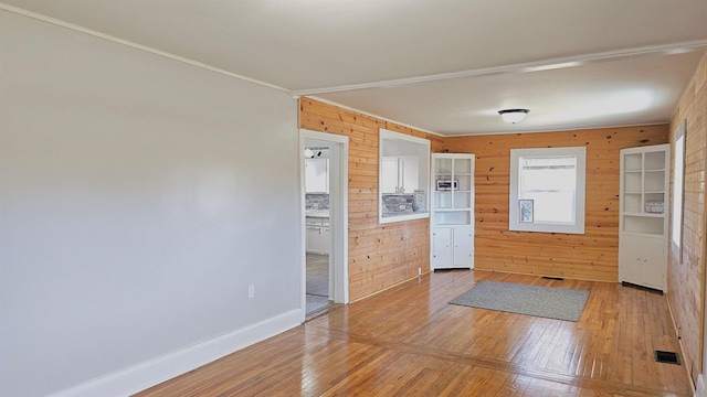 kitchen with wood walls, hardwood / wood-style floors, and ornamental molding