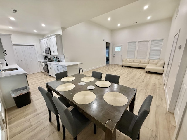 dining space with light hardwood / wood-style flooring and sink