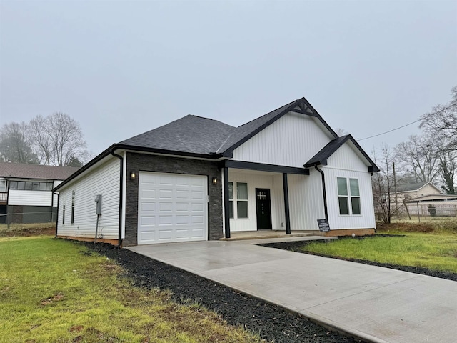 view of front of home with a front yard, a porch, and a garage