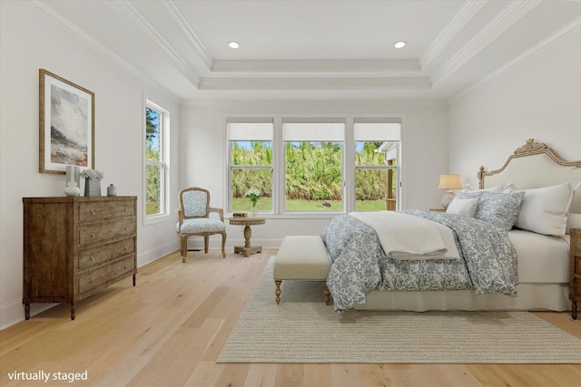 bedroom featuring a tray ceiling, light hardwood / wood-style floors, and ornamental molding