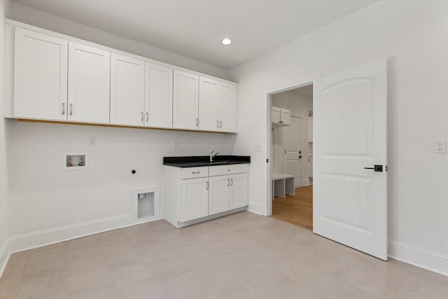 clothes washing area with electric dryer hookup, cabinets, sink, and washer hookup