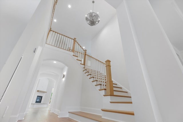 staircase with a high ceiling and a brick fireplace