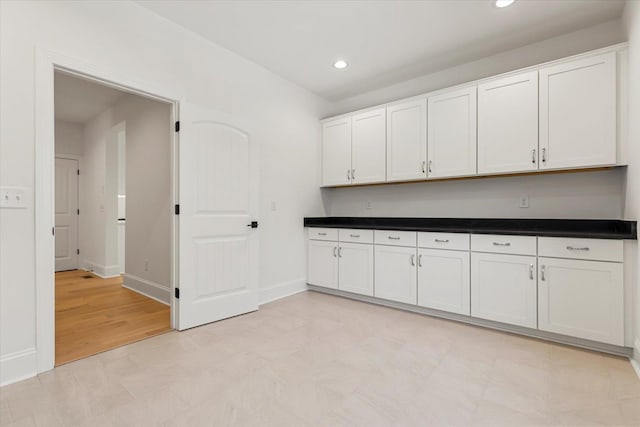 kitchen with light wood-type flooring and white cabinetry